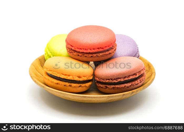 Macarons in wooden plate on white background