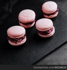 macarons with chocolate filling on black stone