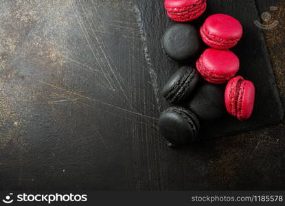 Macaroon cakes on black board. Delicious dessert.