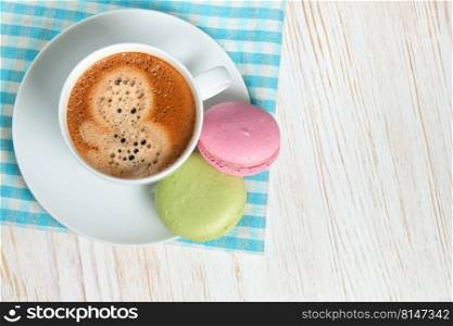 Macaroons and one white cup of coffee. top view, flat lay with copy space for text. Macaroons and cup of coffee
