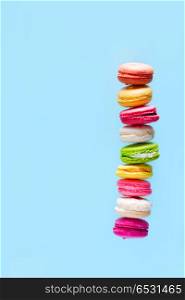 Macaroons cookies on pink. Assorted macaroons cookies tower with copy space on blue background