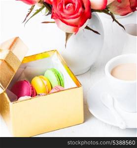 macaroons in gift box and roses in vase