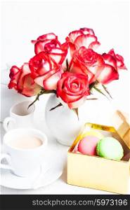 macaroons in gift box and roses in vase. macaroons in gift box