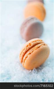 Macaroons on white snow background top, colorful macaroons, selective focus.. Macaroons on white snow background top, colorful macaroons, selective focus