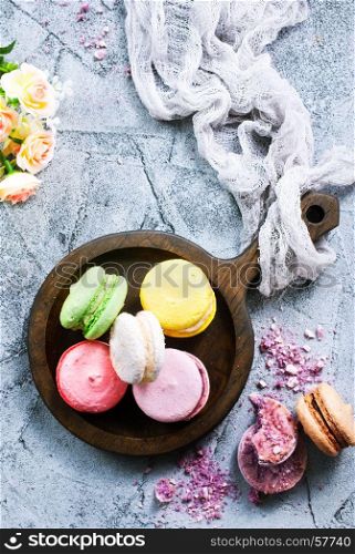 macaroons on wooden plate and on a table