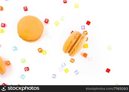 Macaroons with colorful cube letters on white background top, color macaroons, selective focus.. Macaroons with colorful cube letters on white background top, color macaroons, selective focus