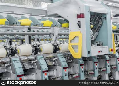 Machinery and equipment in the workshop for the production of thread, close-up. interior of industrial textile factory. spools of thread at a textile factory