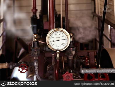 machinery under pressure gauge lets out steam. too much pressure