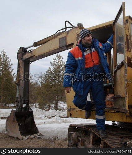 Machinist excavator in a good mood comes from the tractor