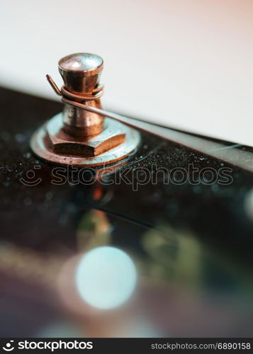 Macro abstract photo of the tuning peg and string of an electric guitar.
