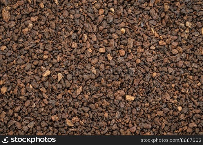Macro background and texture of chicory granules often used with or as a substitute for coffee, made from the root of the chicory plant, Cichorium intybus, also known as endive.