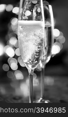 Macro black and white photo of champagne poured into glasses
