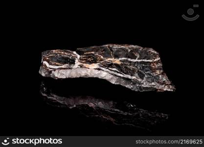 Macro Close up image of raw material Manganese Ore rock isolated on black reflective background