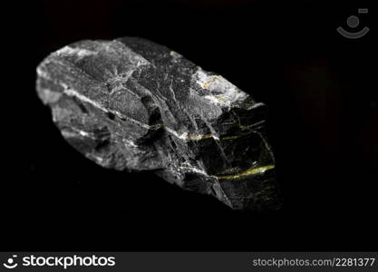 Macro Close up image of raw material Manganese Ore rock isolated on black reflective background