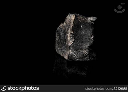 Macro Close up image of raw material Manganese Ore rock isolated on black reflective background