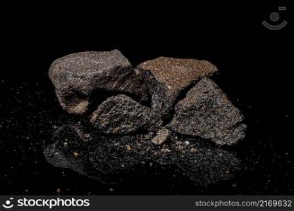 Macro Close up image of raw material Platinum and Chrome Ore rock isolated on black reflective background