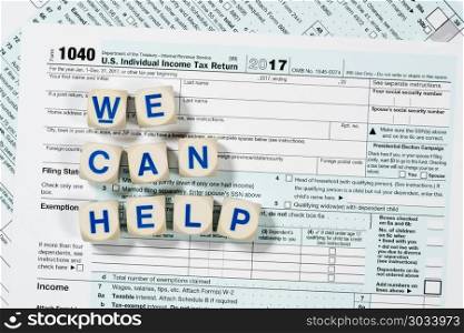 Macro close up of 2017 IRS form 1040 with WE CAN HELP letters. Close macro photo of USA IRS tax form 1040 for year 2017 taken from above with WE CAN HELP spelled out in letters on the form. Macro close up of 2017 IRS form 1040 with WE CAN HELP letters