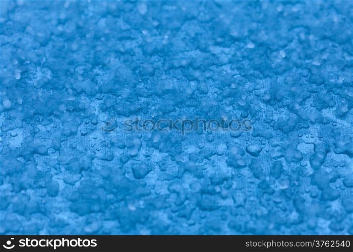 Macro close-up of melt snow as blue background or texture. Winter and seasonal weather.