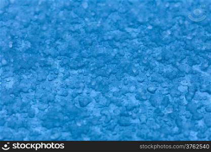 Macro close-up of melt snow as blue background or texture. Winter and seasonal weather.