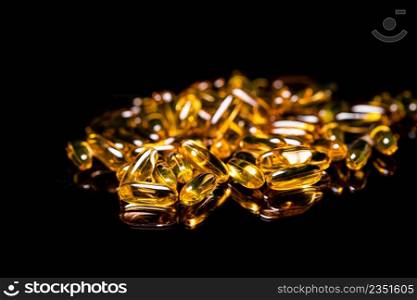 Macro Close up of Omega 3 gel capsule on a reflective black background