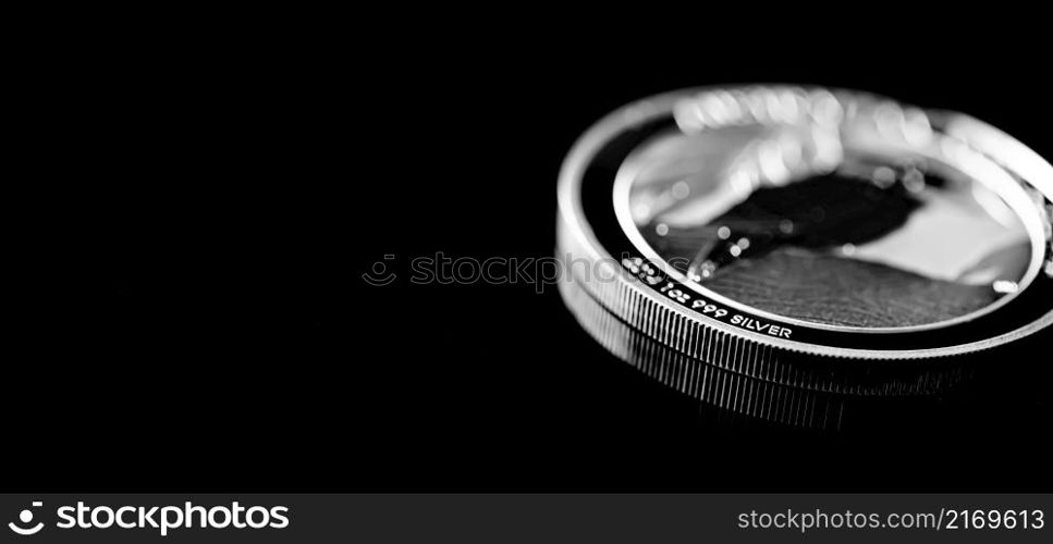 Macro Close up of Silver Bullion Coin on a black mirror background