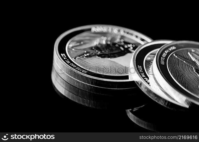 Macro Close up of Silver Bullion Coin on a black mirror background