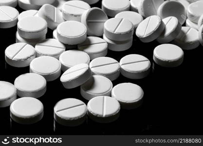 Macro Close up of white painkiller tablet on a reflective black background