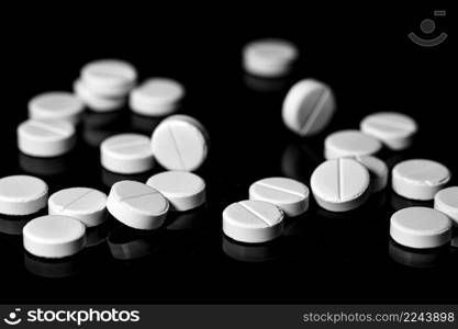 Macro Close up of white painkiller tablet on a reflective black background