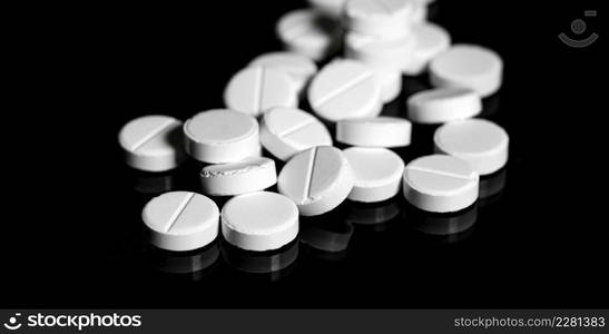 Macro Close up of white painkiller tablet on a reflective black background