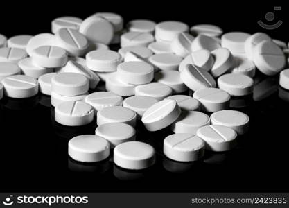 Macro Close up of white painkiller tablet on a reflective black background