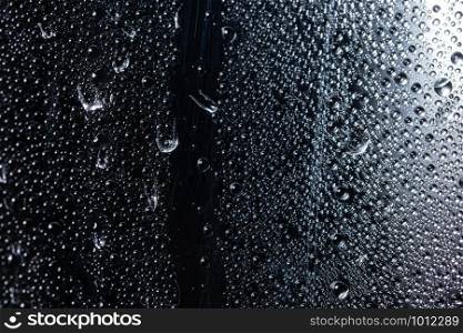 Macro droplet on transparent plastic sheet, black background