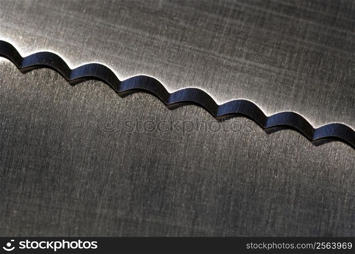 Macro image of a serrated kitchen knife.