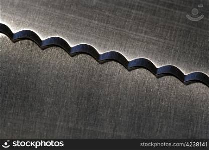 Macro image of a serrated kitchen knife.