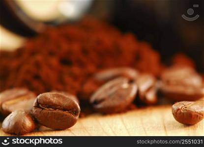 Macro image of coffee beans and ground coffee with black coffee cup
