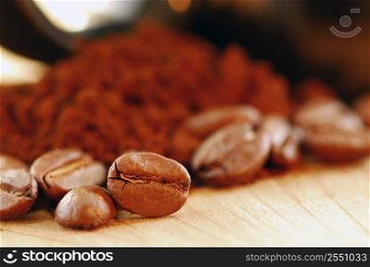 Macro image of coffee beans and ground coffee with black coffee cup