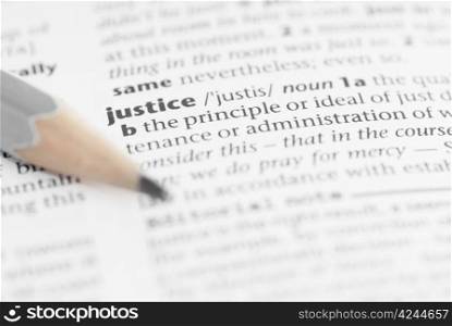 Macro image of dictionary word: Justice, and pencil.
