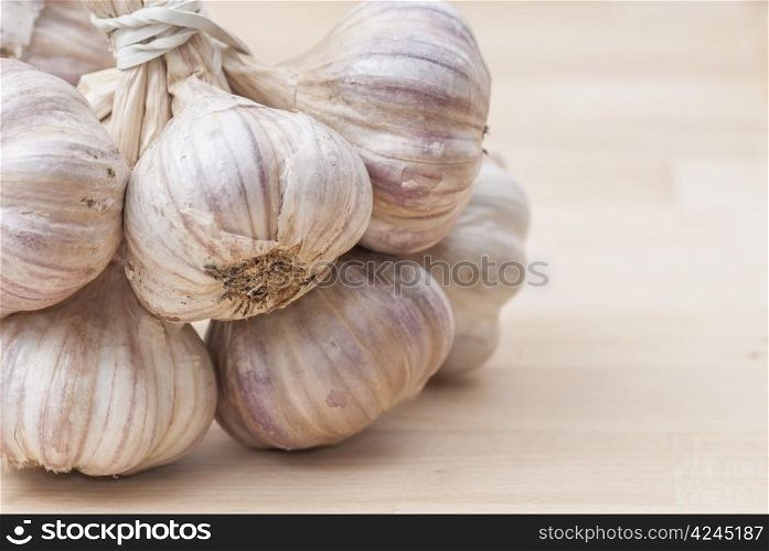 Macro image of garlic against wooden background.