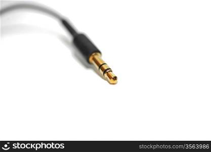 Macro of audio cable isolated on white background with gold connector (jack)