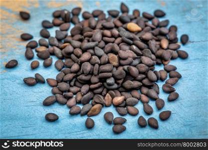 macro of black sesame seeds on a grunge painted wood