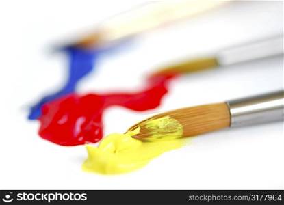 Macro of paintbrushes with paint of primary colors
