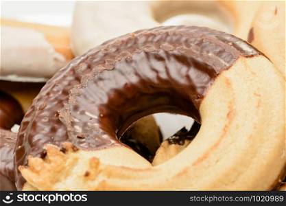 Macro of ring shaped chocolate biscuits in a porcelain plate isolated on white background