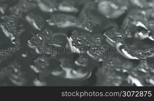 Macro of water sprayed on glass and droplets motion