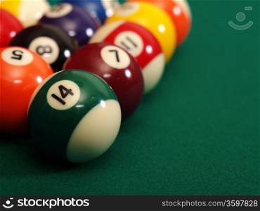 Macro photo of a pool table and billiard balls with space for copy. Shallow depth of field with focus on the fourteen ball.