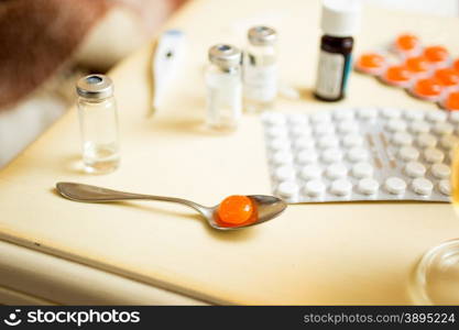 Macro photo of pills in blisters and ampules on bedside table
