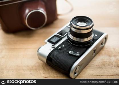 Macro photo of retro manual camera and leather case lying on table