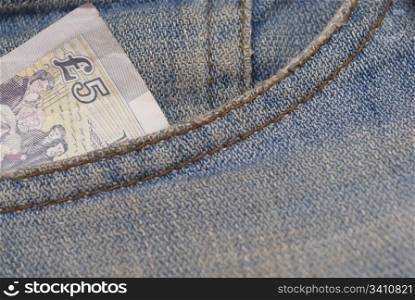 Macro photograph of ?5 sterling in a Jeans pocket.