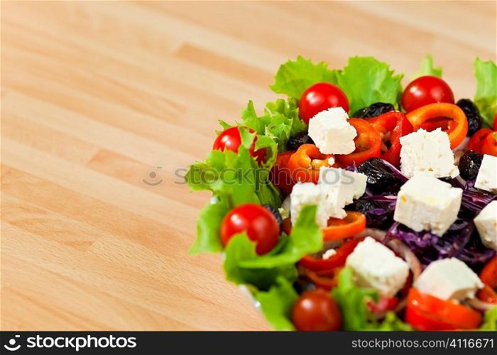 Macro photograph of fresh lettuce, tomato, pepper, black olive, red onion, cabbage salad and feta cheese.