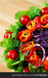 Macro photograph of fresh lettuce tomato pepper olive red onion and cabbage salad