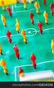 Macro shoot of red and yellow players of tabletop football game.