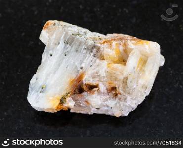 macro shooting of natural mineral rock specimen - native gold in raw quartz stone on dark granite background